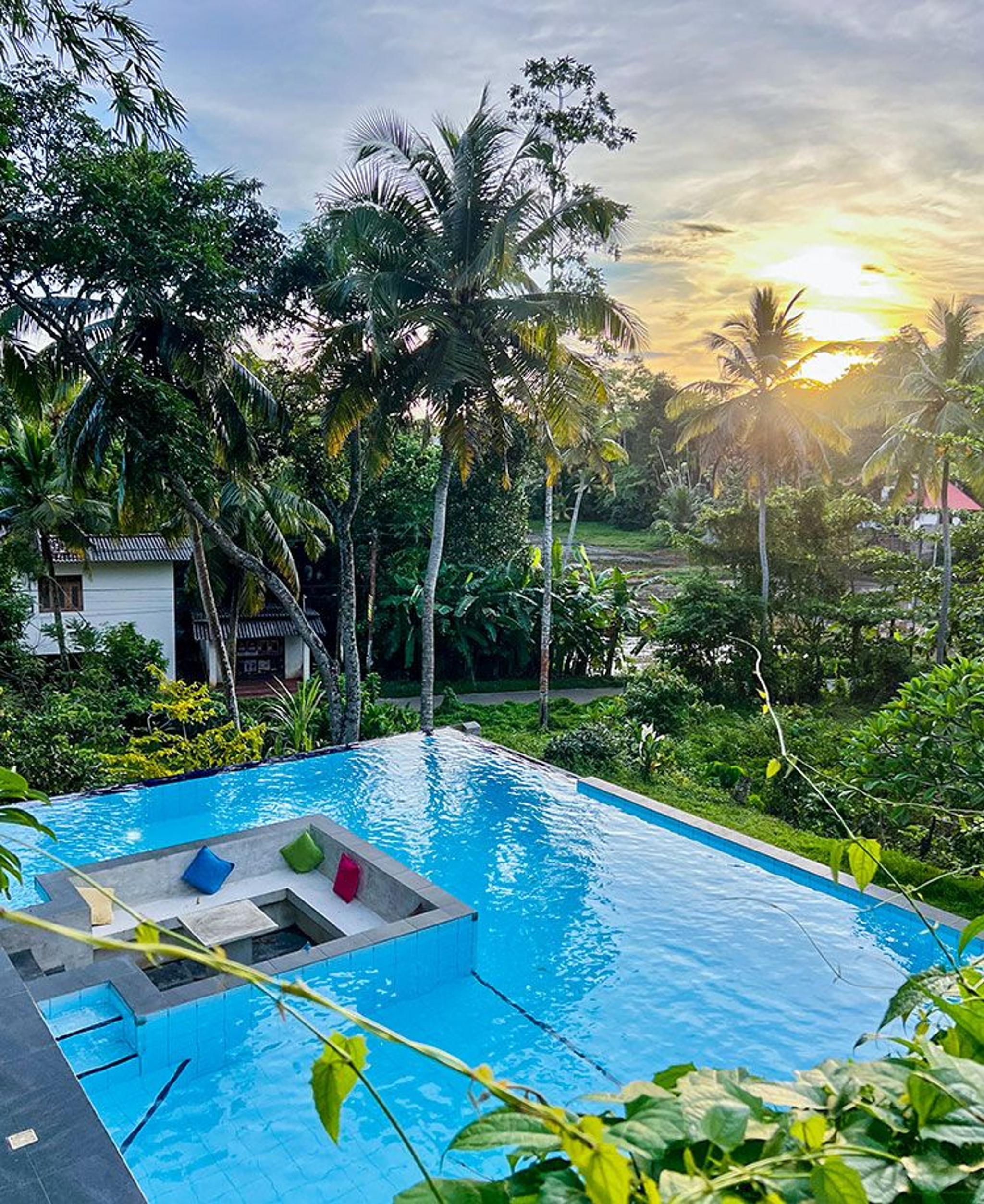 Outdoor swimming pool with palm trees at Muthu Nila Villas