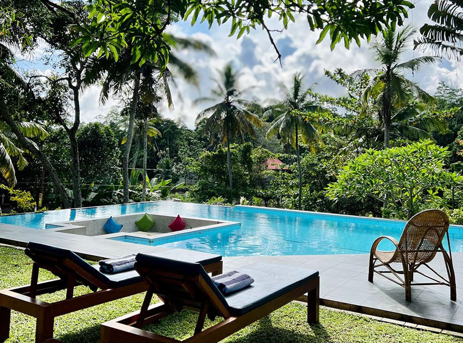 Outdoor pool and lounge chairs at Muthu Nila Villas